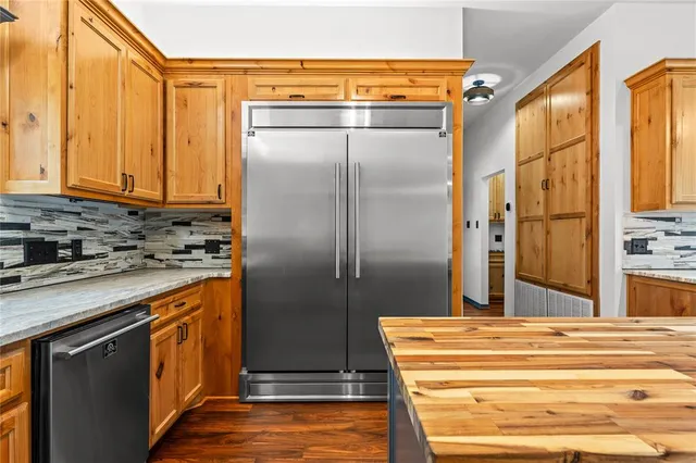 a kitchen with stainless steel appliances granite countertop a refrigerator and a stove