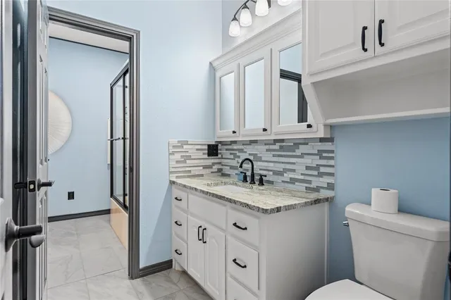a bathroom with a granite countertop sink and a mirror