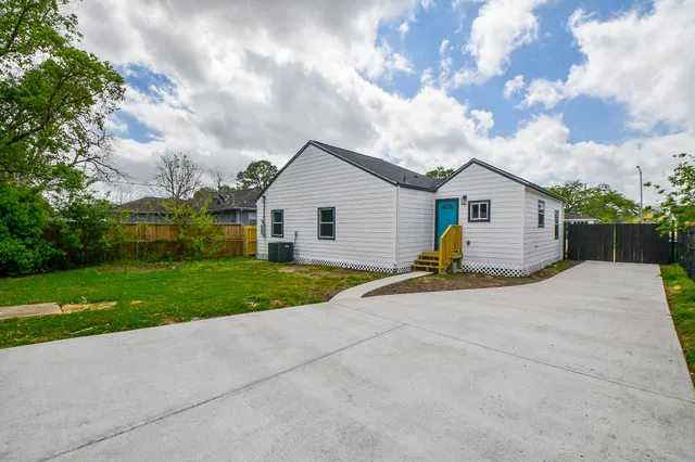 a view of a house with wooden fence and a big yard