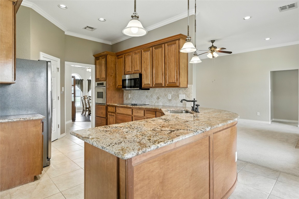 100 Davis Court Thorndale, TX 76577 - Photo 20 of 39 a kitchen with stainless steel appliances granite countertop a sink refrigerator and microwave