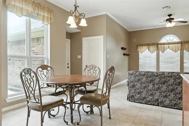 an empty room with windows and chandelier fan