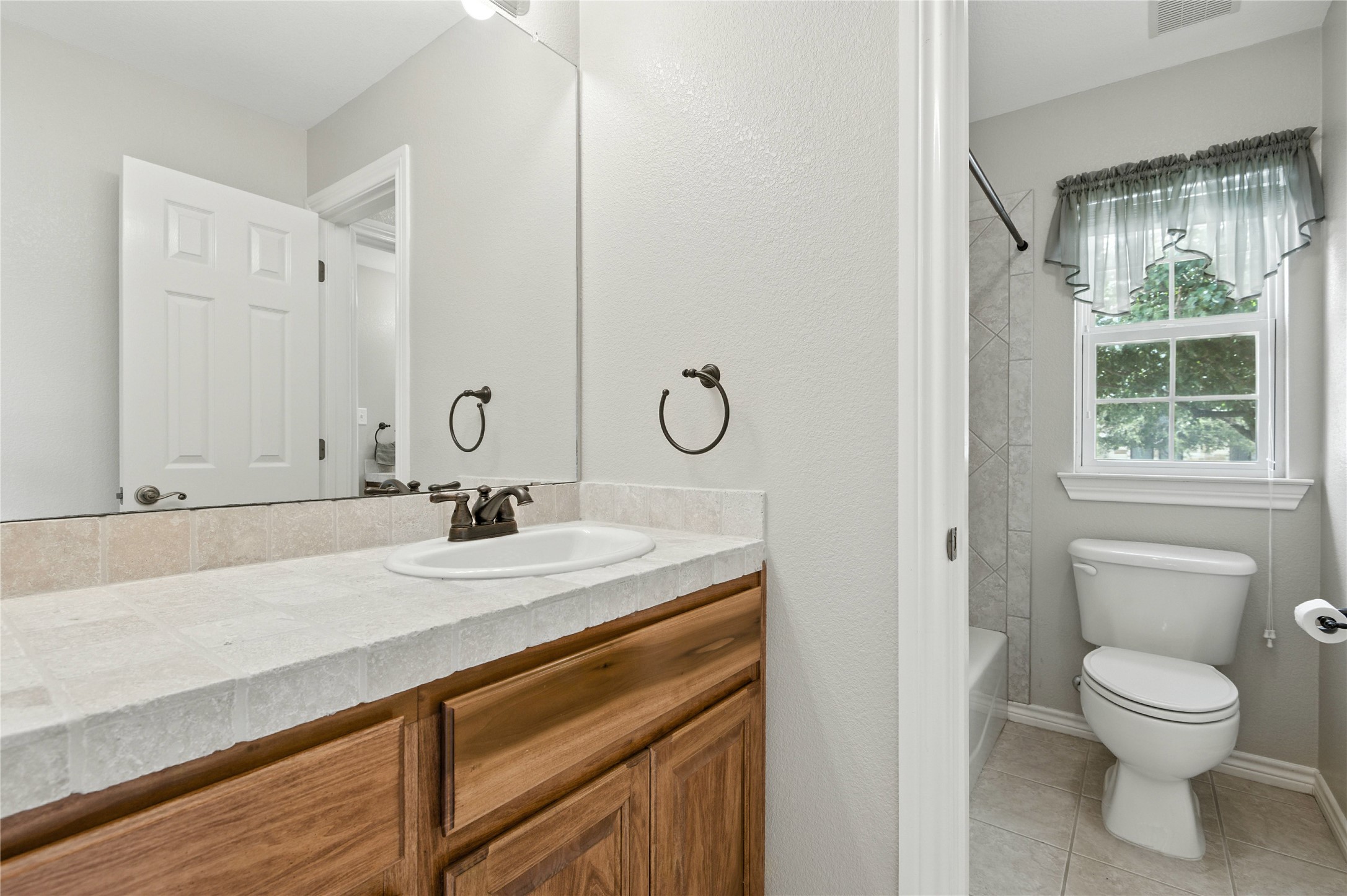 100 Davis Court Thorndale, TX 76577 - Photo 29 of 39 Bathroom featuring vanity, tile patterned floors, and bathing tub / shower combination