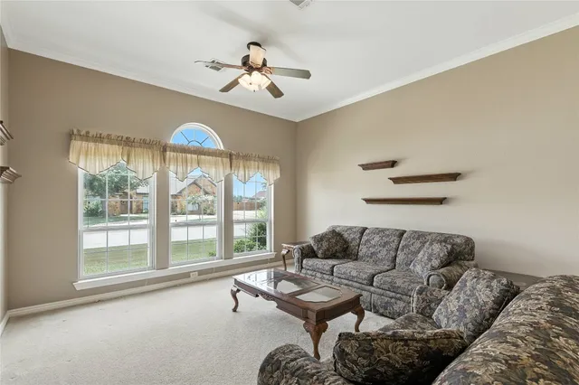 a living room with furniture a couch and a ceiling fan