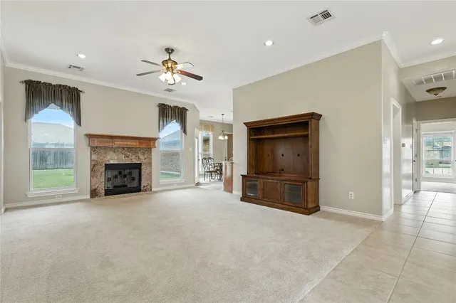 an empty room with fireplace and a ceiling fan