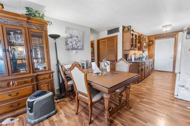 a kitchen with stainless steel appliances granite countertop a table chairs in it and wooden floors
