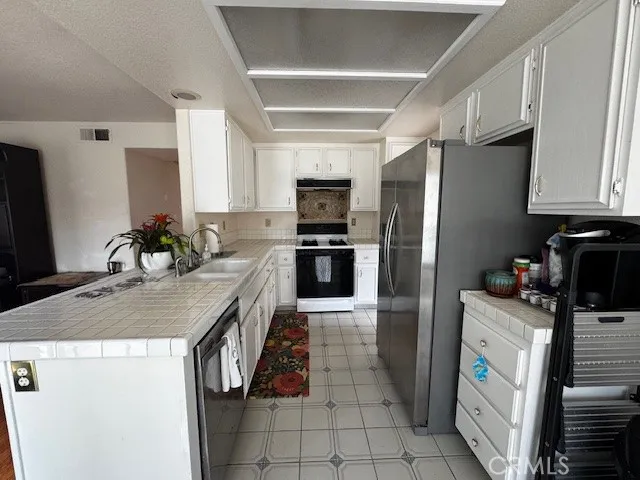 a kitchen with stainless steel appliances granite countertop a refrigerator stove microwave and sink