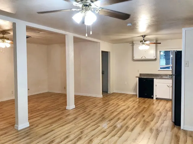 a view of a kitchen with wooden floor and a ceiling fan