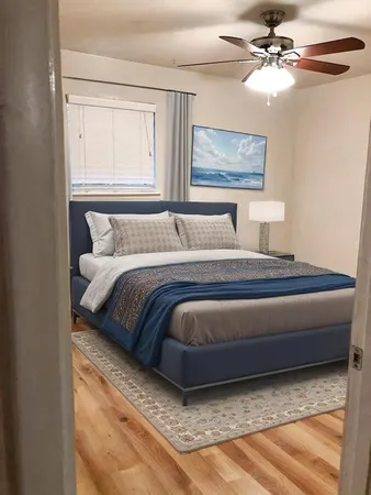 a bedroom with a bed chandelier and a window