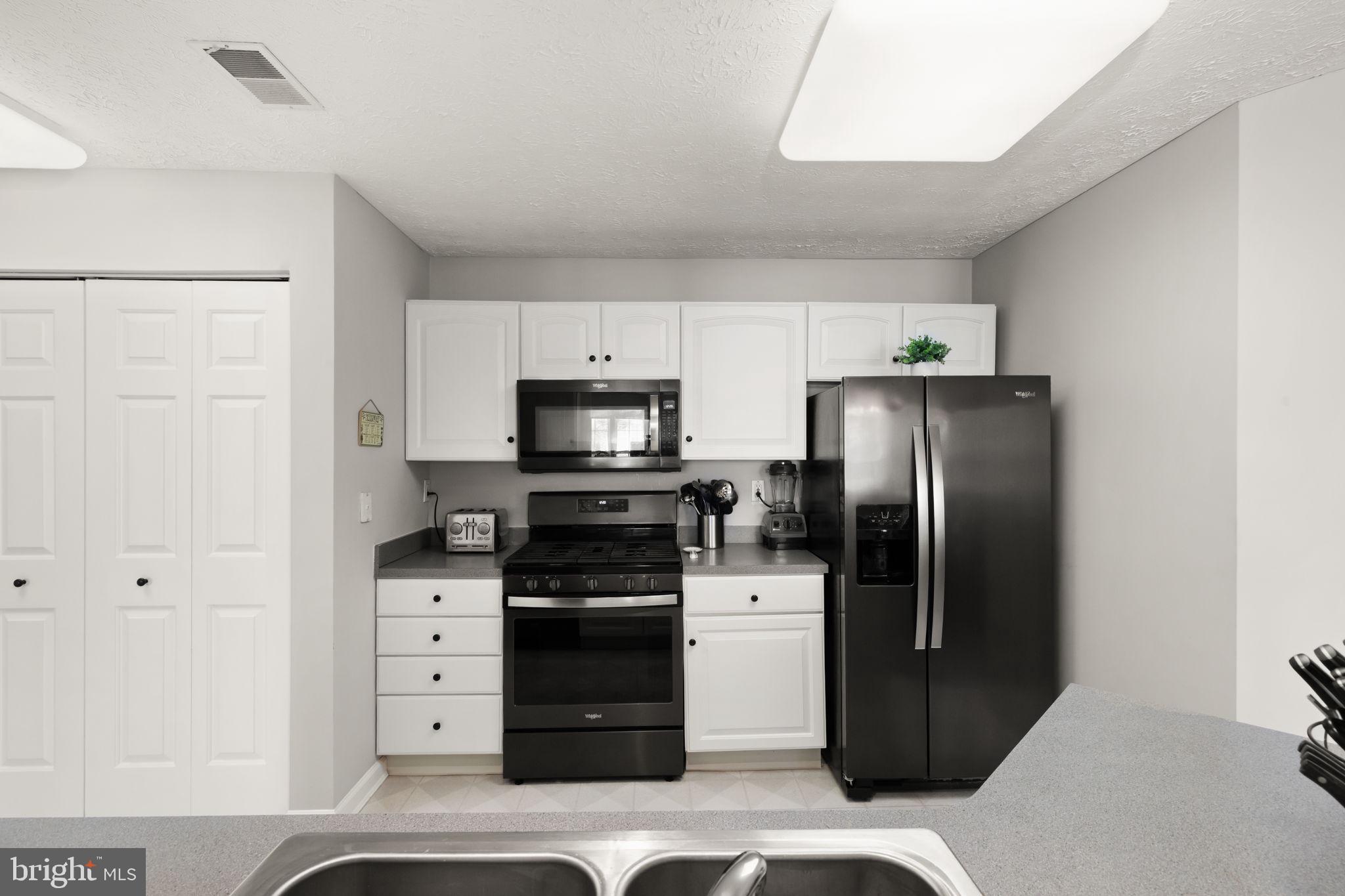 16 Brook Farm Court, Unit 16D Perry Hall, MD 21128 - Photo 2 of 23 a kitchen with stainless steel appliances a refrigerator stove and microwave