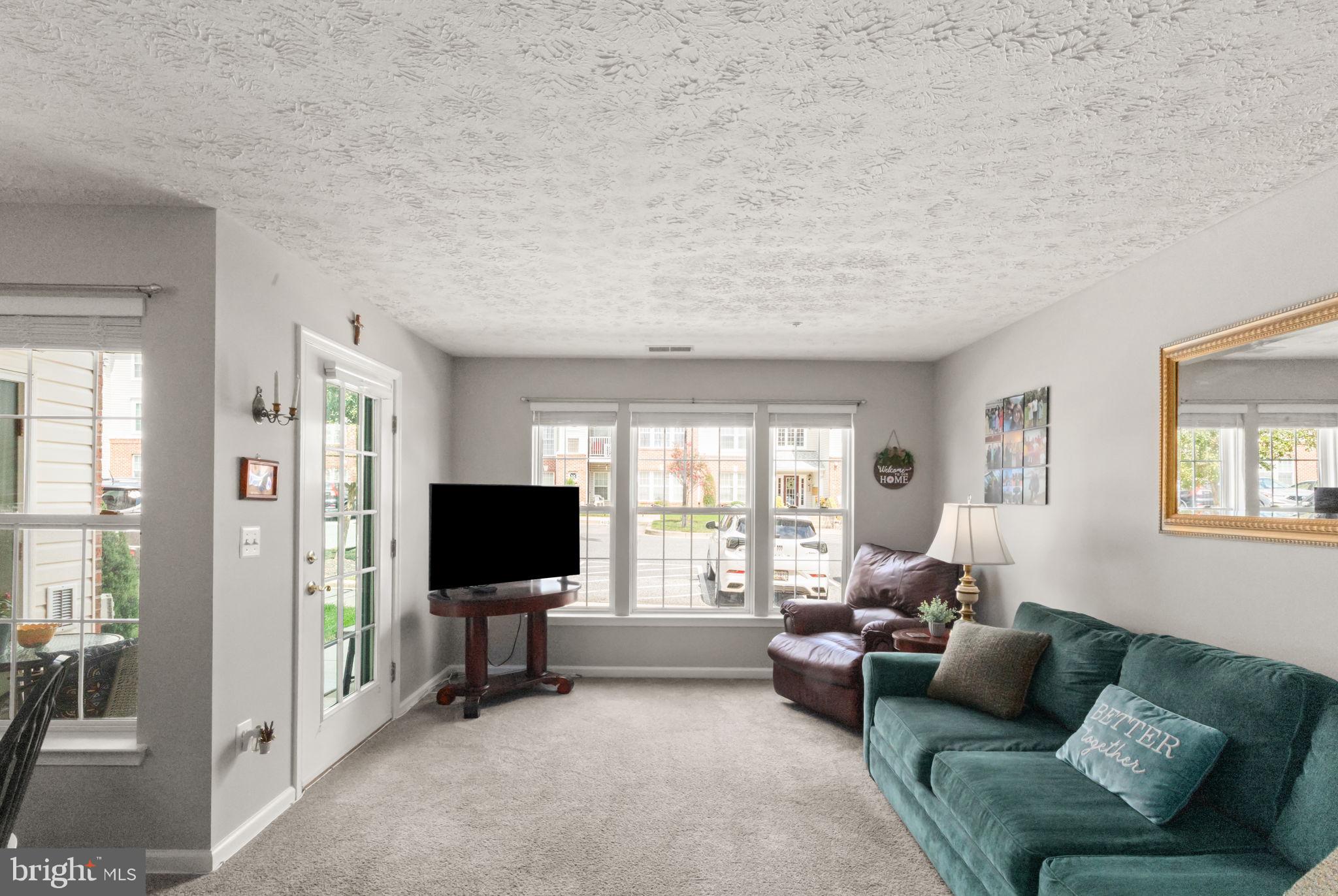 16 Brook Farm Court, Unit 16D Perry Hall, MD 21128 - Photo 7 of 23 a living room with furniture and a flat screen tv