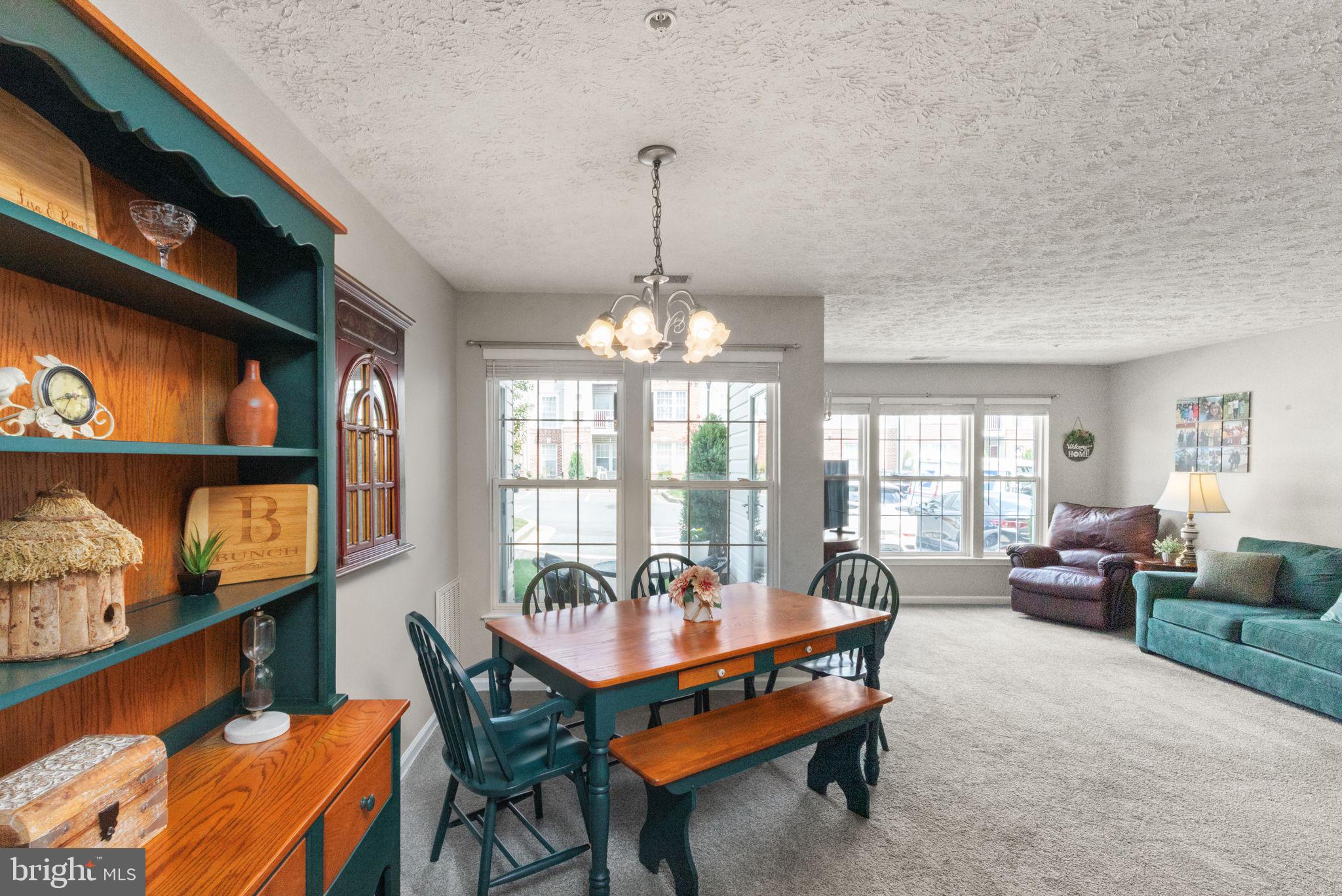 16 Brook Farm Court, Unit 16D Perry Hall, MD 21128 - Photo 9 of 23 a dining room with furniture a rug and a chandelier