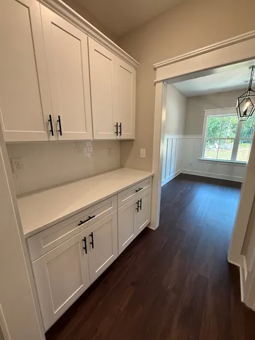 a kitchen with stainless steel appliances a sink cabinets and a wooden floor