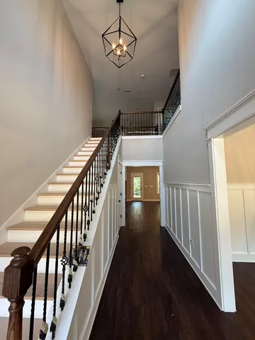 a view of a hallway with wooden floor and staircase