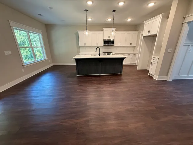 a view of kitchen with stainless steel appliances granite countertop a stove a sink and a refrigerator