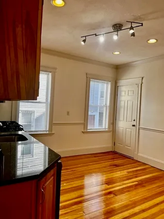 a kitchen with granite countertop a stove cabinets and wooden floor