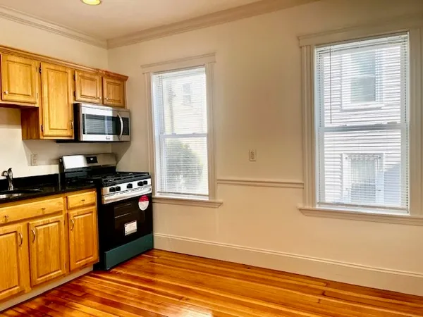 a kitchen with granite countertop a stove a sink and a microwave