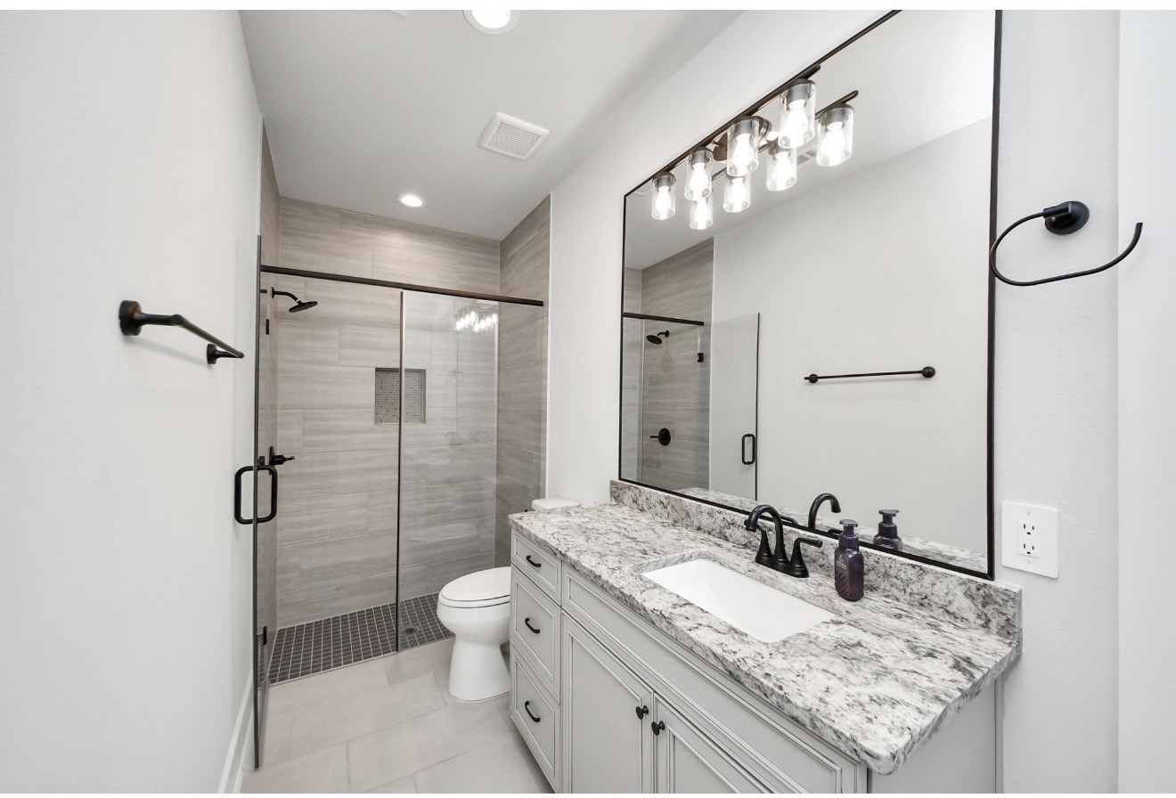 12784 Oak Barrel Road Willis, TX 77378 - Photo 17 of 28 a bathroom with a granite countertop sink a toilet and shower