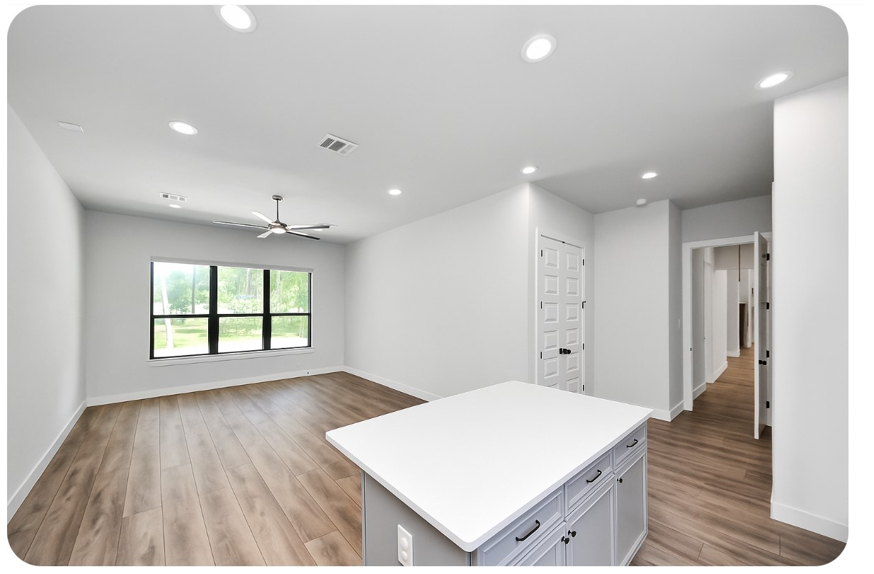 12784 Oak Barrel Road Willis, TX 77378 - Photo 22 of 28 a large white kitchen with wooden floor and a sink