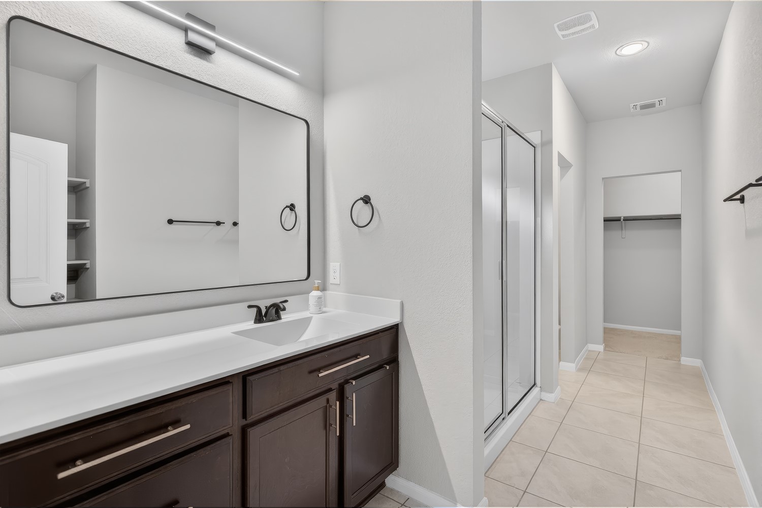 2006 Grow Lane Austin, TX 78754 - Photo 13 of 40 A well-lit primary bathroom featuring a spacious vanity, walk-in shower, and ample storage.