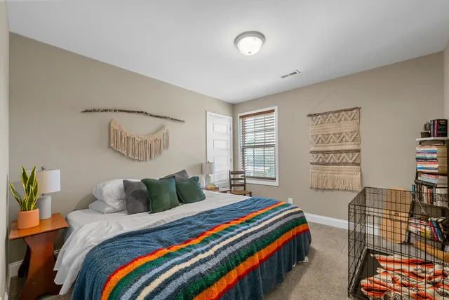 a bedroom with a bed and a painting on the wall