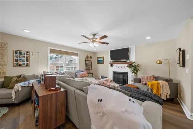 a living room with furniture a flat screen tv and a fireplace