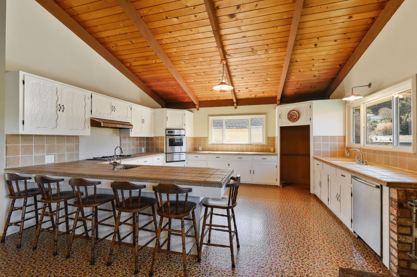 991 Zamora Drive Pacifica, CA 94044 - Photo 18 of 26 a kitchen with stainless steel appliances granite countertop a table chairs and wooden floors