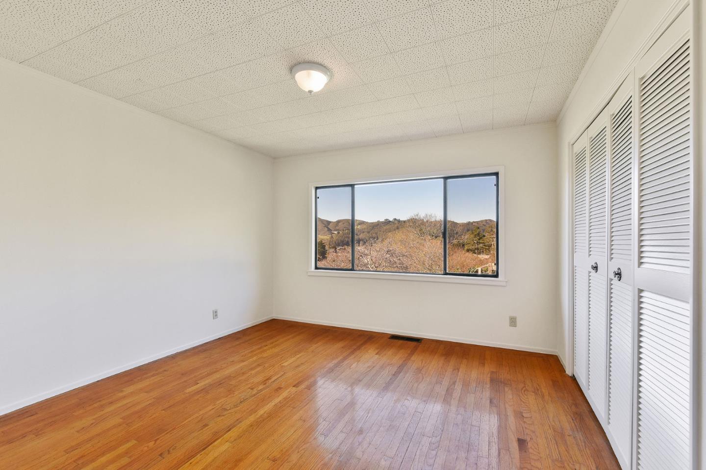 991 Zamora Drive Pacifica, CA 94044 - Photo 24 of 26 an empty room with wooden floor and windows