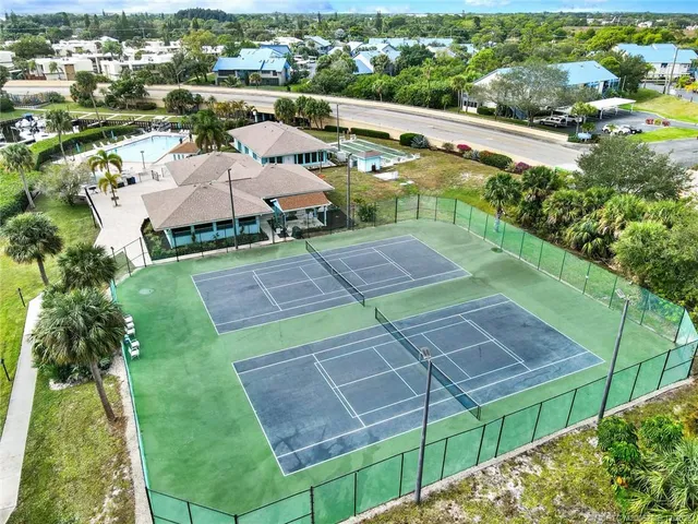 an aerial view of a house with swimming pool and outdoor seating