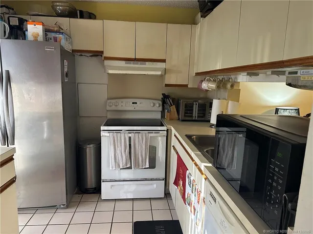 a kitchen with stainless steel appliances granite countertop a stove a refrigerator and a sink