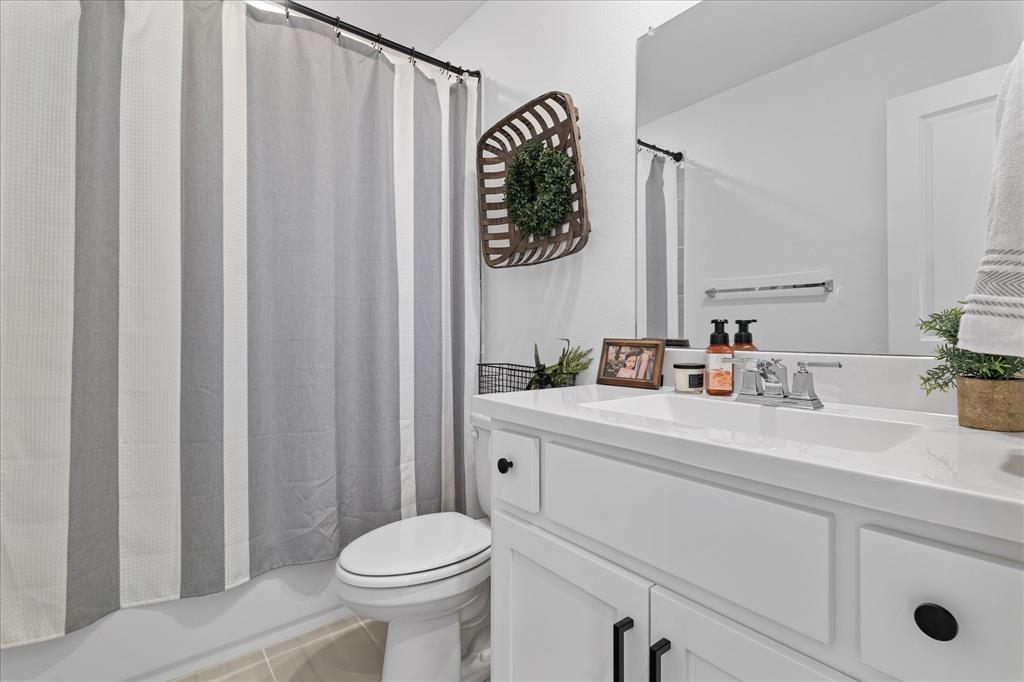 1332 Thompson Road Argyle, TX 76226 - Photo 20 of 36 Bathroom with vanity, shower / bath combination with curtain, and light tile patterned floors