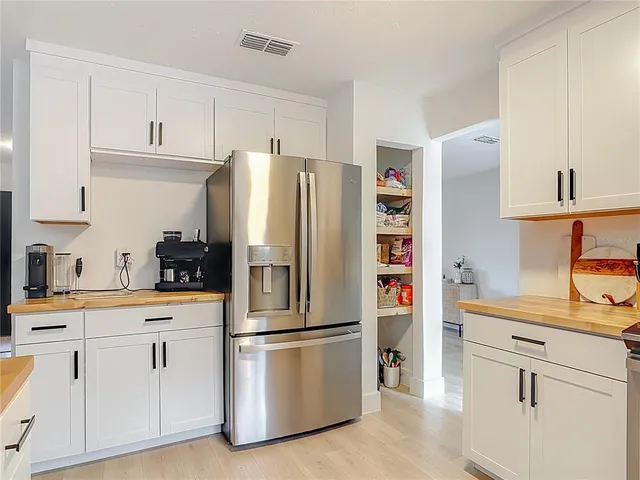 a kitchen with stainless steel appliances a refrigerator sink and cabinets