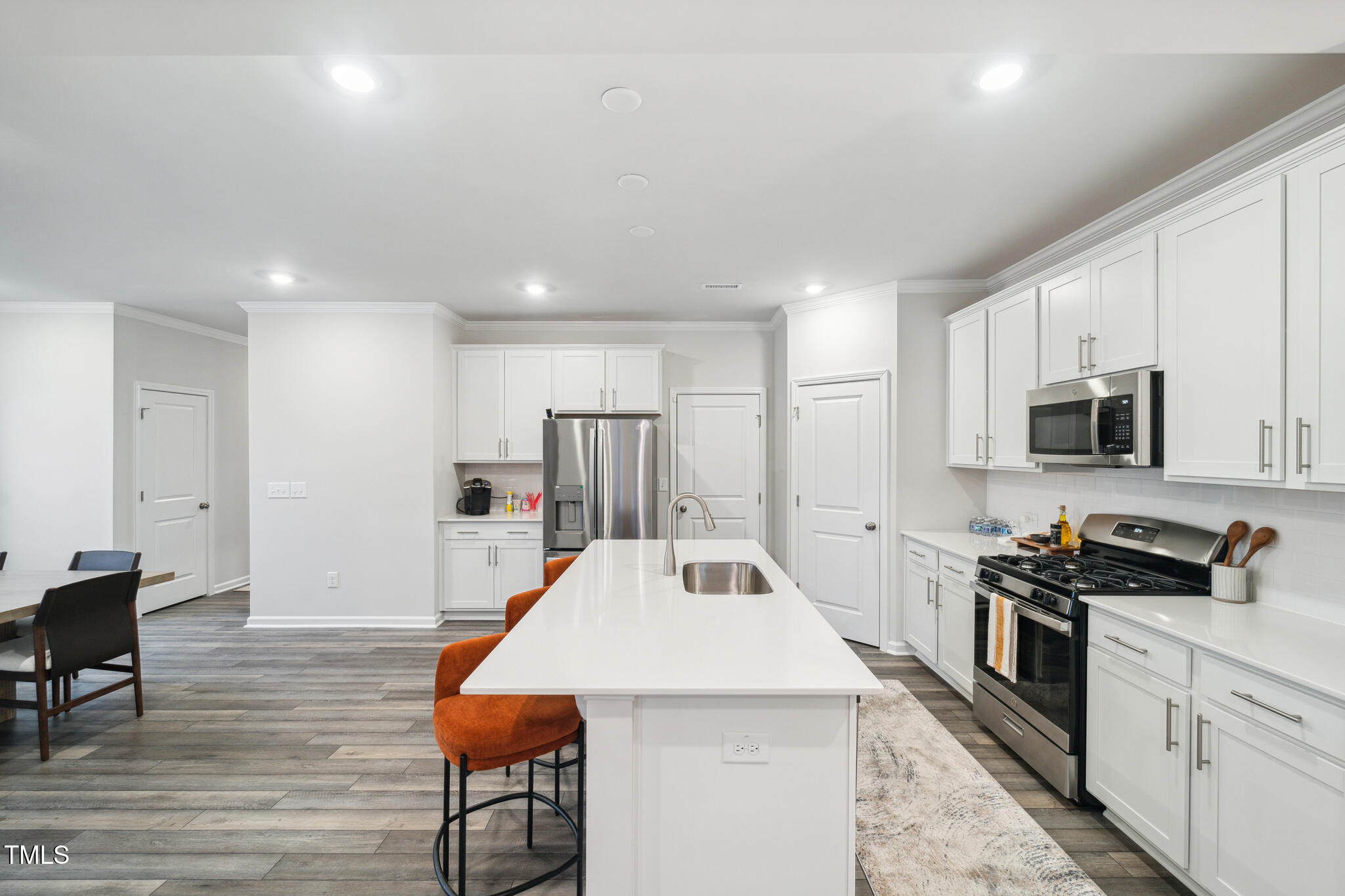 720 Maple Br Circle Graham, NC 27253 - Photo 9 of 40 a kitchen with stainless steel appliances kitchen island granite countertop a stove a sink a refrigerator and white cabinets with wooden floor