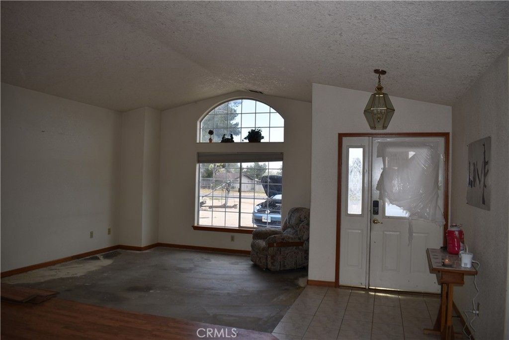 19485 Kinai Road Apple Valley, CA 92307 - Photo 3 of 12 an empty room with windows and cabinet