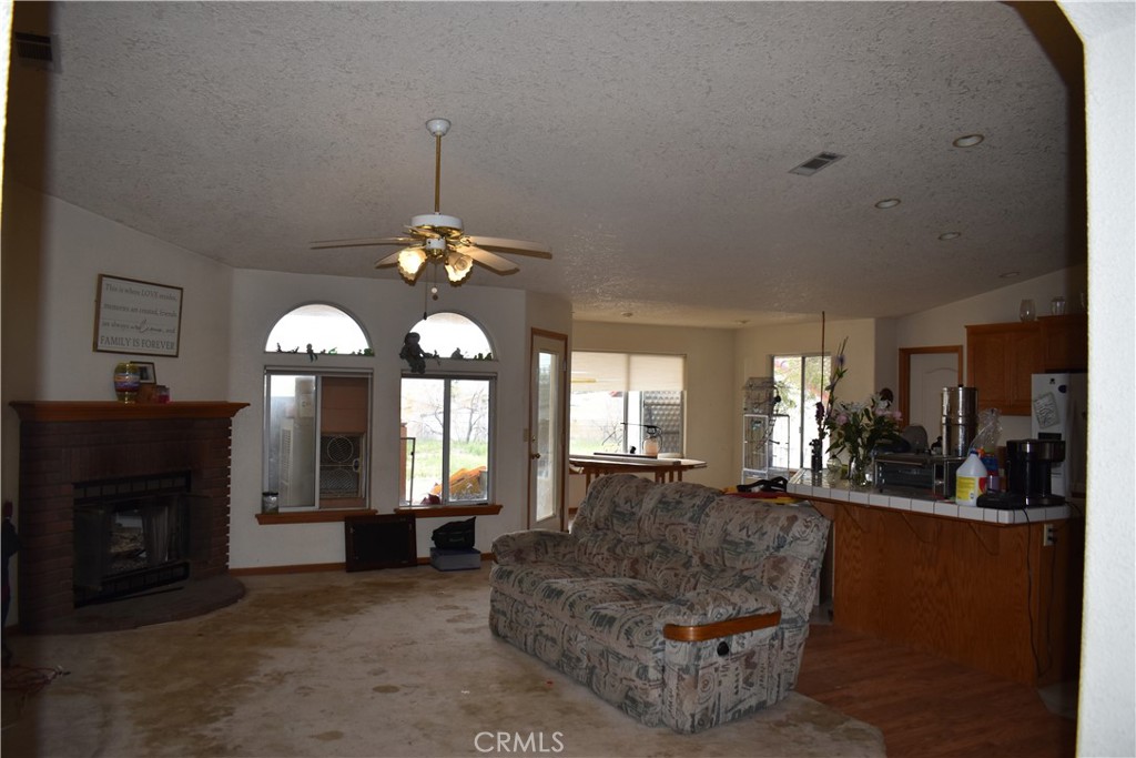 19485 Kinai Road Apple Valley, CA 92307 - Photo 5 of 12 a living room with furniture a large window and a fireplace