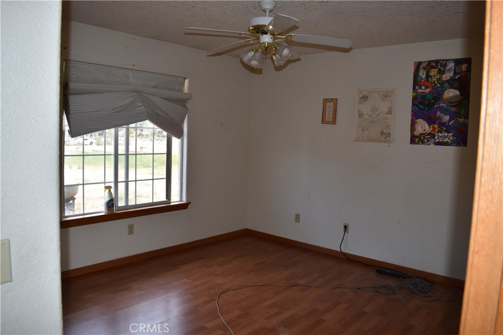 19485 Kinai Road Apple Valley, CA 92307 - Photo 10 of 12 an empty room with windows and fan
