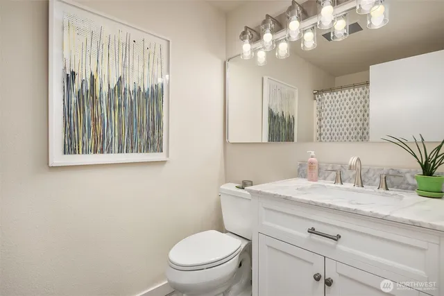 a bathroom with a toilet a sink and mirror