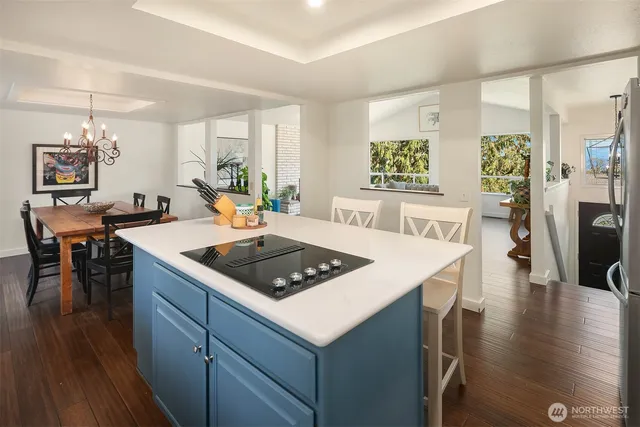a living room with kitchen island a table and chairs in it