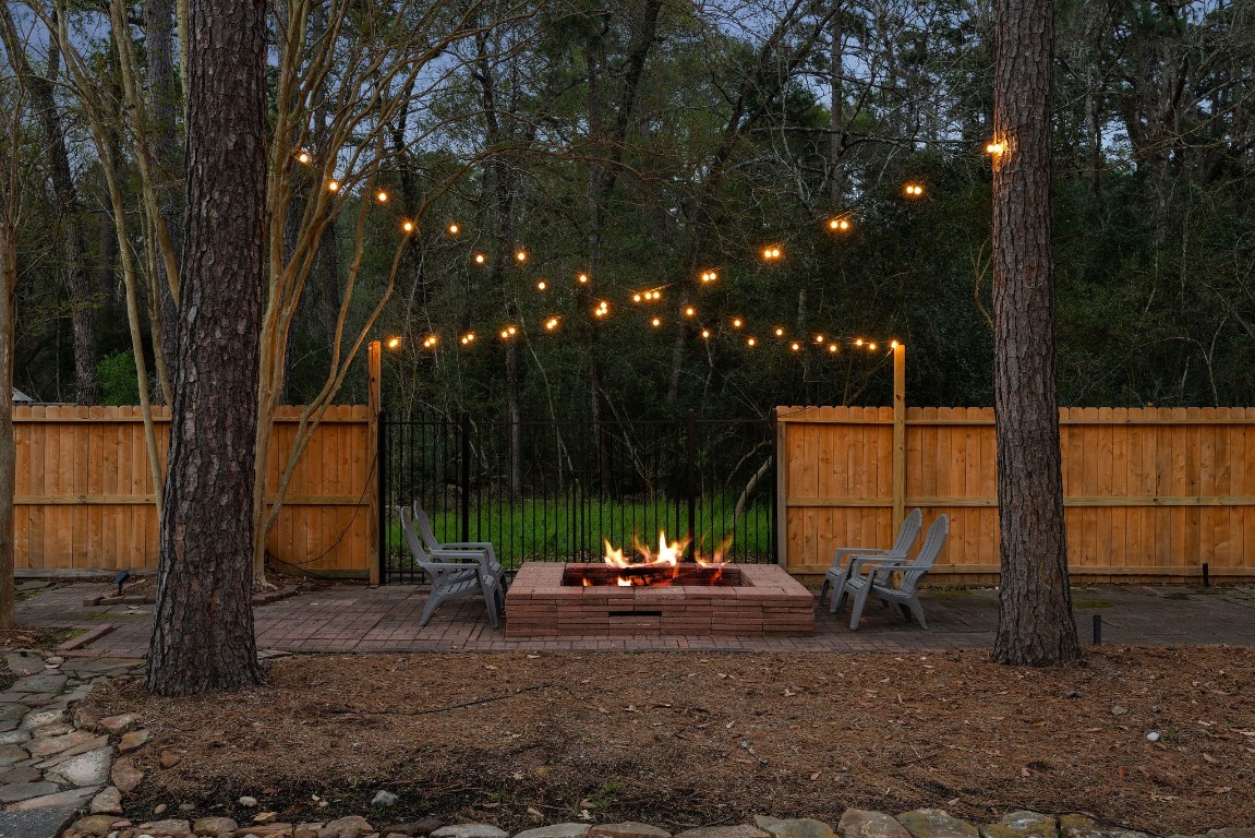 2 North Thundercreek Place Spring, TX 77381 - Photo 34 of 47 A large fire pit is perfect for an evening under the stars - the iron gate is your personal access to the wooded reserve with creeks and walking trails.