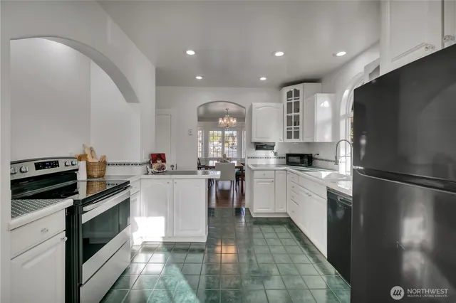 a kitchen with a refrigerator a stove top oven and cabinets
