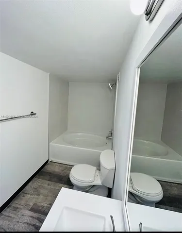 a bathroom with a toilet and a bath tub