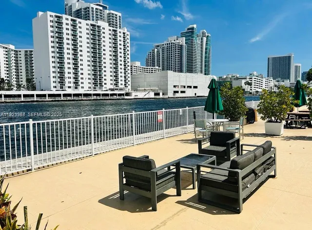 a view of roof deck with couches and wooden fence