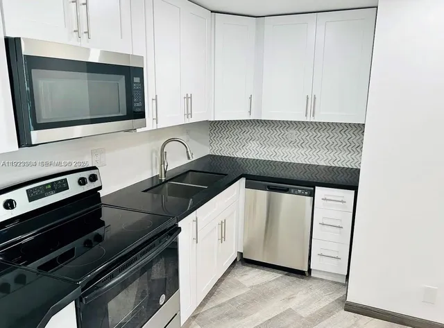 a kitchen with a stove microwave and sink