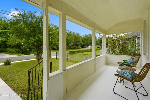 a view of a porch with furniture and a yard