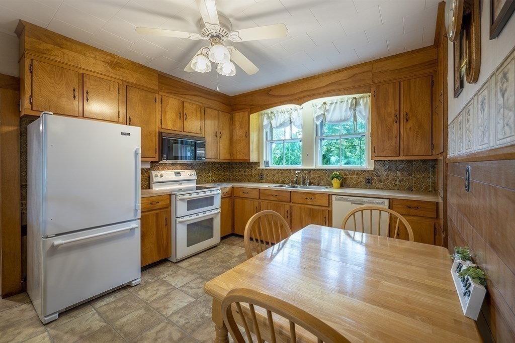 23 Salem Road Billerica, MA 01862 - Photo 7 of 42 a kitchen with a refrigerator a stove a sink dishwasher with a dining table and chairs