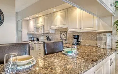 a kitchen with granite countertop a stove a sink and a granite counter tops