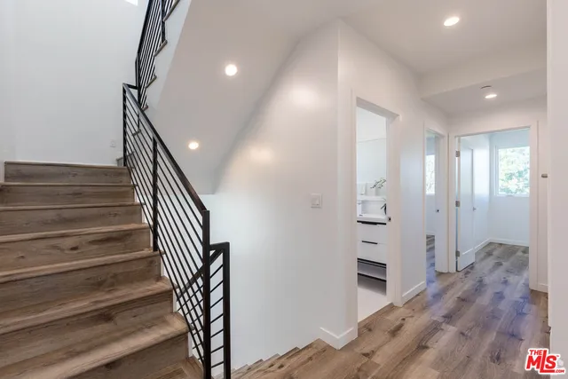 a view of a hallway with wooden floor and staircase
