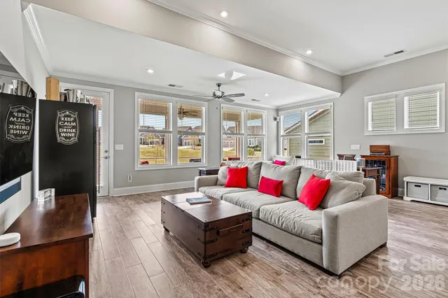 a living room with furniture kitchen view and a large window