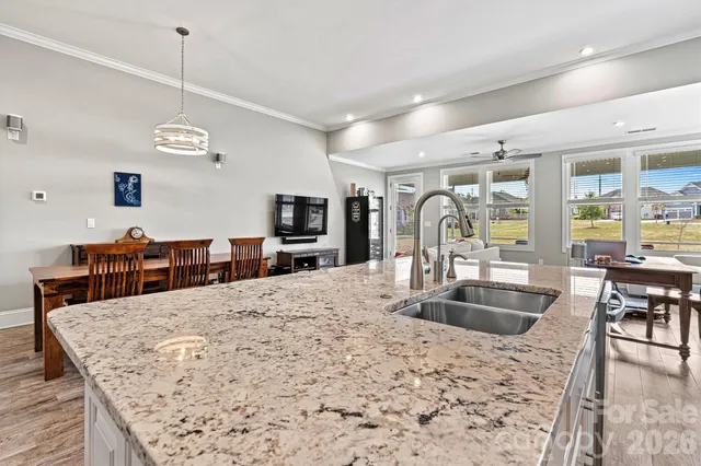 a kitchen with stainless steel appliances kitchen island granite countertop a sink stove and refrigerator