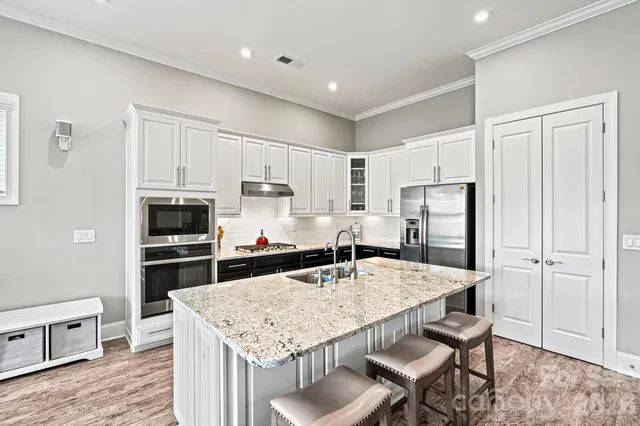 a kitchen with kitchen island a refrigerator stove microwave and cabinets