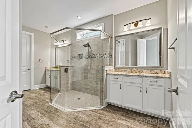 a bathroom with a granite countertop sink mirror and shower